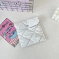 Dettaglio della borsa trapuntata bianca con chiusura a bottone a pressione a cuore blu - crema