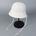 Detail of breathable knit bucket hat showing soft cream texture and woven tie-straps - M (56-58cm) / White