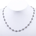 Detail of blue daisy floral necklace with yellow center and silver chain on model - Steel+Dark Blue