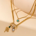 Dettaglio della collana dorata a strati con ciondolo a serpente e turchese - Stile Serpente Turchese Oro