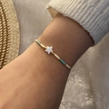 Detail of woven seed bead bracelet with white starfish charm and gold accents - White