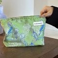Green vintage floral makeup bag with bird pattern and satin finish in hand - Magpie Green