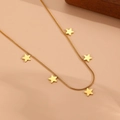 Vue détaillée d'un collier chaîne serpent dorée avec pendentifs étoiles sur fond beige - Collier Étoile Doré