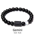 Detail of Gemini constellation bead bracelet with obsidian stones and blue accent bead - Gemini