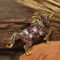 Golden unicorn brooch pin with pink crystals on a rustic wooden background - Purple Unicorn