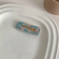 Detail of blue and pink marble acetate hair clip with gold metal clamp on a tray - Blue Marble Square
