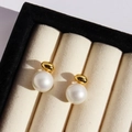 Elegante Ohrstecker mit Goldperle und weißer Perle in einer beigen Schmuckschatulle - Gold