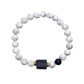 Primer plano de cuentas de turquesa blanca con detalle negro y anillos dorados brillantes - Turquesa Blanca y Cuentas Negras Mates Con Turmalina