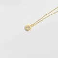 Minimalist gold necklace with a round pendant featuring a diamond-encrusted letter P - Letter P