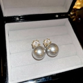 Primo piano di orecchini con perle grigio argento e zircone con montatura a griffe oro - Perla Grigia Base Dorata (HE21628) / Grigio Argento