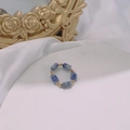 Dettaglio macro dell'anello elastico con pietre di marmo blu e distanziatori dorati - Pietra Macchiata Blu Bianca Oro