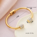 Brazalete de acero inoxidable chapado en oro 18K con cilindros y brillantes, apertura en C - Dorado