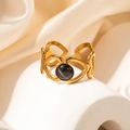 Macro detail of golden heart-shaped cutout ring with a black round cat eye stone - Black Stone Heart Open Ring