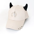 Detail of beige baseball cap featuring black demon horns and metal ring embellishments - Half Ring Smiley Beige