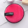 Disco desmaquillante redondo de microfibra rosa con etiqueta Clean Sponge en una revista - Rojo