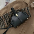 Classic black structured handbag with gold clasp, set on autumn scarves for a luxury look - Black