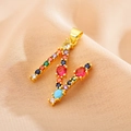 Detailed macro view of gold letter M pendant with colorful zirconia inlays - Letter N