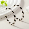 Detail of large C-shaped hoop earrings with black, white, and gold spiral twist texture - Eco-friendly White and Black in KC Gold