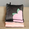 Detail of pink quilted blanket unfolding from a grey cushion with peach embroidery - Peach / Folded 40x40cm Unfolded 115x145cm