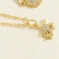 Dettaglio di ciondoli a stella marina e sole dorati con zirconi su una catena sottile - Collana Stella Marina con Zirconi