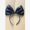 Detailed view of a black satin bow headband on a simple textured craft background - Satin Bow / Black