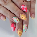 Dettaglio di unghie a mandorla con smiley sole, motivi a scacchi e nail art floreale - Sole Smiley a Scacchi Fiore (AW362)