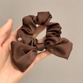 Detailaufnahme eines braunen Satin-Haargummis mit Schleife und glänzender Stoffoberfläche - Satin-Stil / Satin Kaffee