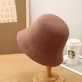 Detail of dark brown wool cloche bucket hat on wooden stand with warm textured finish - M (56-58cm) / Camel