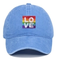 Detailed view of rainbow pride flag patch with white LOVE embroidery on blue washed denim cap - One Size / Light Blue