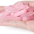 Hand holding multiple rose quartz hexagonal prism pendants with natural ice crack texture - Rose Quartz