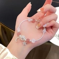 Pink strawberry crystal beaded bracelet with silver star and moon charms on wrist - Silver-Pink-Star Moon