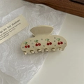 Macro view of cream hair claw clip with red rhinestone cherry pattern on white paper - White Rhinestone Cherry Claw
