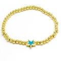 Detailed macro of golden beaded bracelet with blue enamel star pendant on white backdrop - Lake Blue