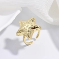 Dettaglio dell'anello dorato a forma di stella marina su sfondo di tessuto bianco - Stella martellata oro