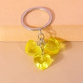 Detalle de dijes de corazón de resina amarilla en un llavero de metal plateado - Amarillo