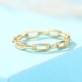 Vue macro d'une bague chaîne dorée à maillons ovales sur fond bleu clair moderne - US 7 / Or