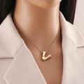 Dettaglio del ciondolo a lettera V placcato oro 18K su una catena a maglia fine - Lettera V