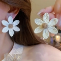 Gros plan de boucles d'oreilles fleurs tressées blanches portées par un mannequin - 3# Tige en acier - Fleur tissée blanche dorée