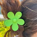 Matte mint green flower hair claw clip worn on hair in an outdoor nature setting - 7cm / Green