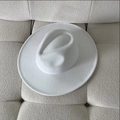 Bovenaanzicht van een witte breedgerande vilten hoed op een beige stoffen bank - M (56-58cm) / Wit