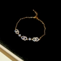 Dettaglio di bracciale a catena d'oro con anelli di cristallo intrecciati e chiusura a moschettone - Bracciale-Oro-Doppi Anelli (Placcato Oro Reale)