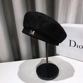 Elegante basco in pizzo nero da donna con logo M dorato su un supporto per cappelli - Decorazione della lettera M / Nero