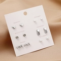 Detail of 6 pairs of pearl and zircon stud earrings on pink weekly card with silk background - Silver Heart Pineapple LOVE