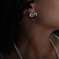 Polished silver heart stud earrings with asymmetric design worn by a female model - Brown/Silver
