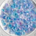 Cuentas de resina en forma de flor azul y morado con copos de oro en plato blanco - 20g (Aprox. 110 unidades) / Degradado Azul Oscuro