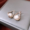 Macro shot of French gold-plated twisted pearl hoop earrings on a textured jewelry box - Hoop - Chocolate Gold