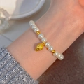 Elegant white pearl bracelet featuring golden leaf charm and spacer beads on wrist - Gold Leaf Pendant Pearl (MY38018)