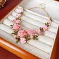 Dettaglio di collana con fiori rosa, foglie verdi e perle in una scatola per gioielli - Collana Rosa Rosa