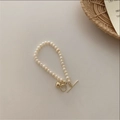 Detail of freshwater pearl bracelet featuring a gold T-bar clasp and small bell charm - 35# Round Ball Pearl Bracelet