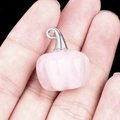 Pink quartz pumpkin pendant with a silver metal loop shown on a hand in high detail - Rose Quartz